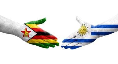 Uruguay ve Zimbabwe bayrakları arasındaki el sıkışma ellerinde izole şeffaf görüntü.