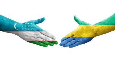 Ellerine Özbekistan ve Gabon bayrakları arasında el sıkışma, izole şeffaf görüntü.