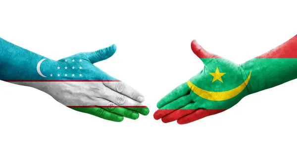 stock image Handshake between Uzbekistan and Mauritania flags painted on hands, isolated transparent image.