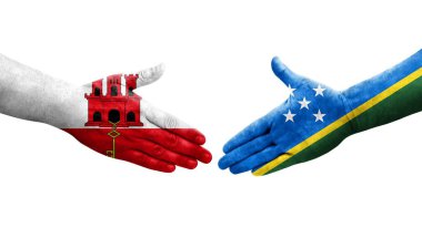 Solomon Adaları ve Cebelitarık bayrakları arasındaki el sıkışma..