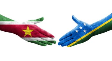 Solomon Adaları ve Surinam bayrakları arasındaki el sıkışma ellerinde izole şeffaf görüntü.