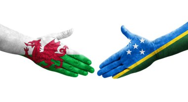 Solomon Adaları ve Galler arasındaki el sıkışma ellerinde boyanmış bayraklar, yalıtılmış şeffaf görüntü.