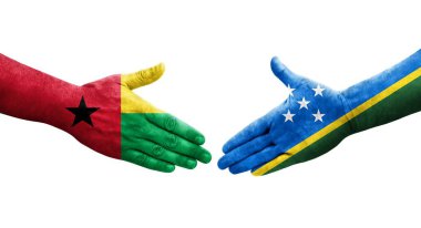 Solomon Adaları ve Gine Bissau bayrakları arasındaki el sıkışma ellerinde izole şeffaf görüntü.