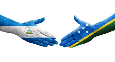 Solomon Adaları ve Nikaragua bayrakları arasındaki el sıkışma ellerinde izole şeffaf görüntü.