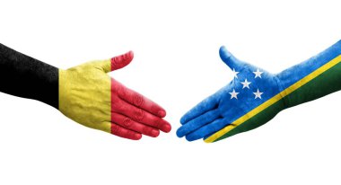 Solomon Adaları ve Belçika bayrakları arasındaki el sıkışma ellerinde izole şeffaf görüntü.