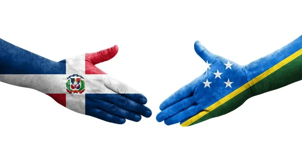 stock image Handshake between Solomon Islands and Dominican Republic flags painted on hands, isolated transparent image.