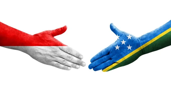 stock image Handshake between Solomon Islands and Indonesia flags painted on hands, isolated transparent image.