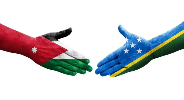 stock image Handshake between Solomon Islands and Jordan flags painted on hands, isolated transparent image.