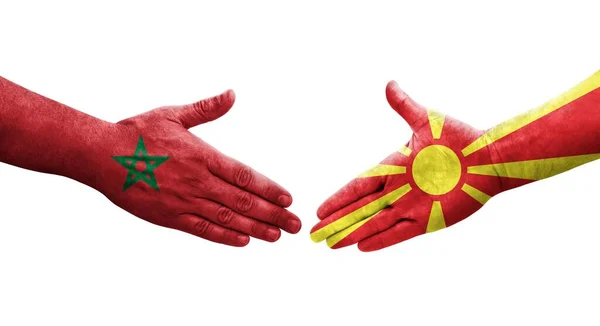 手に描かれた北マケドニアとモロッコの旗の間の握手 孤立した透明なイメージ — ストック写真