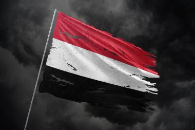 Yemen, karanlık gökyüzü arka planında parçalanmış bayrak.