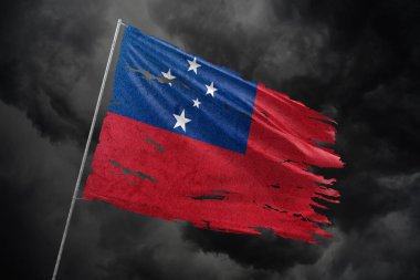 Karanlık gökyüzü arka planında yırtık Samoa bayrağı.
