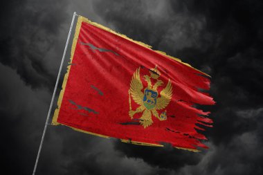 Karadağ 'ın koyu gökyüzü arka planında yırtık bayrak.