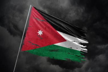 Ürdün, karanlık gökyüzü arka planında parçalanmış bayrak.