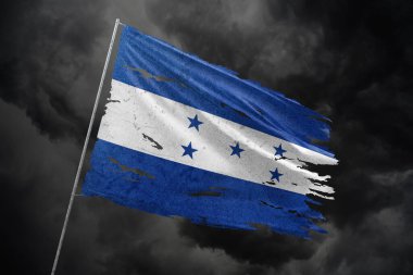 Karanlık gökyüzü arkaplanında Honduras bayrağı yırtıldı.