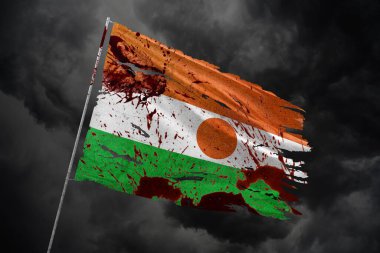 Karanlık gökyüzü arka planında kan lekeleriyle Nijer 'in yırtık bayrağı.