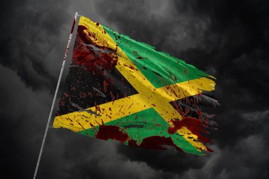Jamaika 'nın koyu gökyüzü arka planında kan lekeleriyle yırtılmış bayrağı.
