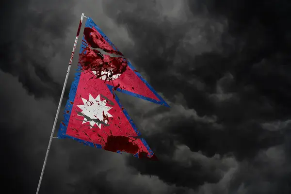 Koyu gökyüzü arka planında kan lekeleriyle Nepal bayrağı yırtıldı.