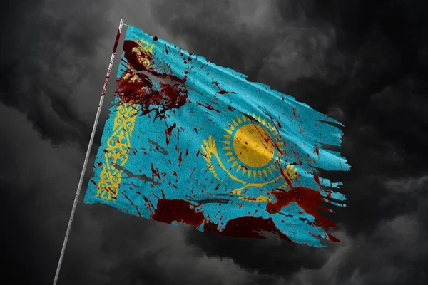 Kazakhstan torn flag on dark sky background with blood stains.