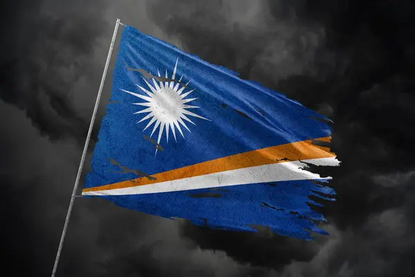 マーシャル諸島は暗い空の背景に旗を引き裂いた ストック画像