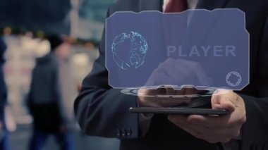 Tanınmayan iş adamı akıllı telefon oynatıcısı üzerinde hologram kullanıyor. Havaalanı ya da tren istasyonunun arka planında holografik ekranı olan ceketli bir adam.