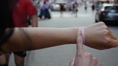 Kadın el, akıllı bilezik üzerindeki kavramsal HUD hologramları onaylanmış metinle etkinleştirir. Şehrin arka planında holografik teknolojisi olan tanınmayan bir kadın.