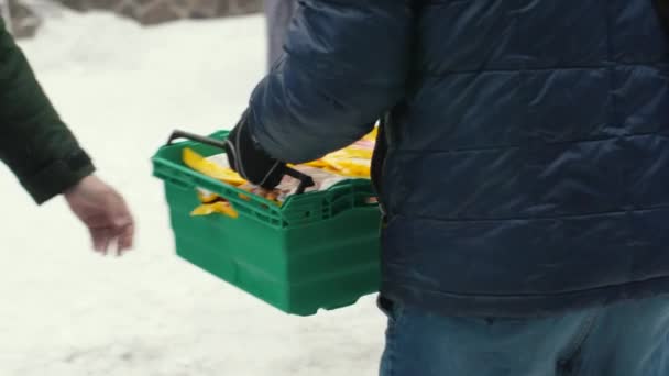 사슬은 손에서 식료품 상자를 통과합니다 수없는 봉사자는 난민을위한 음식의 플라스틱 — 비디오