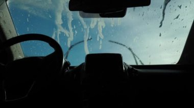 Dışarıdan yüksek basınçlı su jeti ile arabayı yıkamak. Arabayı kendin temizliyorsun. Otomobil yıkama, arabanın içinden görüntü.