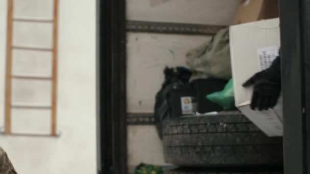 손에서 상자를 통과합니다 수없는 봉사자는 트럭에서 피난민을위한 상자를 내립니다 — 비디오