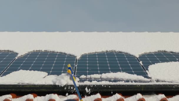 清理雪地上的太阳能电池板冬季太阳能电池板 无法辨认的人清除了太阳能电池板上的积雪 冬季可再生能源 冬季使用太阳能电池板发电 — 图库视频影像