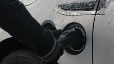 Eldivenli eller EV 'den güç bağlantısını kopar, kapat. Tanınmayan biri elektrik kablosunu elektrikli arabadan ayırır, pilleri şarj eder. Kışın elektrikli araç veya PHEV şarj etmek