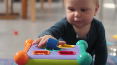 Neşeli çocuk, öğrenmeyi teşvik eden aktiviteler yoluyla ince motor becerileri ve bilişsel gelişimi geliştirmek için dizayn edilmiş renkli bir şekillendirme oyuncağıyla oynuyor.