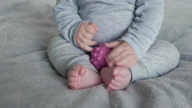 Tanımlanamayan bebek, rahat bir battaniyenin üzerinde bağdaş kurarak oturur ve topa yumru yumru dokunur. Bebekler küçük eller ve ayaklar masumiyet ve rahatlık duygusunu barışçıl bir şekilde tamamen somutlaştırır.