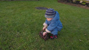 Mavi ceketli küçük bir çocuk, yemyeşil çimenlerin üzerinde paslı bir lokomotifle oynayarak saf masumiyeti ve sonsuz mutluluğu temsil ediyor.