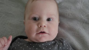 Sevimli bebek, masumiyet dolu, duygularını sevimli bakışlar ve gülümsemelerle ifade ediyor, onları değerli aile anlarını yakalamak ve kalıcı anılar yaratmak için ideal kılıyor, üstten bakıldığında