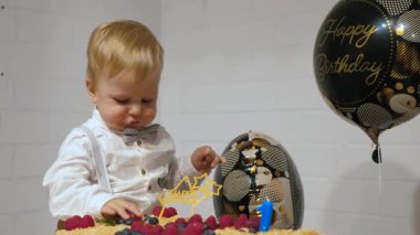 Dağınık elleri ve yüzüyle yeni yürümeye başlayan çocuk ilk doğum günlerini büyük pasta, canlı ve renkli balonlar ve heyecanla kutluyor. Saf çocukluk sevinci ve masumiyeti somutlaştırıyor.