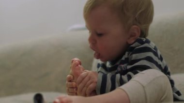 In a cozy environment, a joyful baby plays with his tiny feet, showing curiosity and a desire to explore. These moments create an atmosphere of wonder and happiness