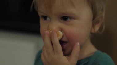 In a warm and cozy environment, the baby experiences pure joy as he savors a delicious slice of tangerine. His sweet facial expressions and natural curiosity fill the room with joy
