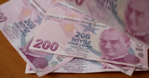 200リラのトルコのリラ紙幣がテーブルの上と上に落ちる 経済問題の概念とトルコリラの価値の減価償却 — ストック動画