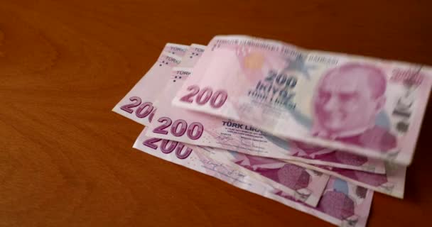 200リラのトルコのリラ紙幣がテーブルの上と上に落ちる 経済問題の概念とトルコリラの価値の減価償却 — ストック動画