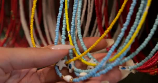 Женская Рука Крупным Планом Сортирует Ожерельям Синих Желтых Бусин Цвета — стоковое видео