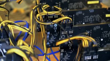 Büyük bir çiftlikte kripto para madenciliği ekipmanı. Hayranları olan elektronik cihazların yakın çekimleri, ana kartta birçok video kartı, kripto para birimi madencileri. Pasif gelir kavramı.