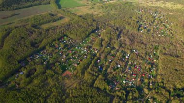 Orman ve ormandaki mavi gölle çevrili bir banliyö köyünün üzerinde uçan bir drondan ateş ediliyor. Şehir dışındaki yaşam kavramı, doğada modern şehirlerden ve medeniyetten uzakta..