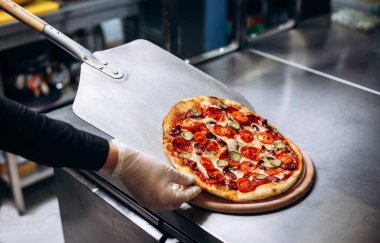 Pizzacıdaki fırına pizza koyarken yakın çekim