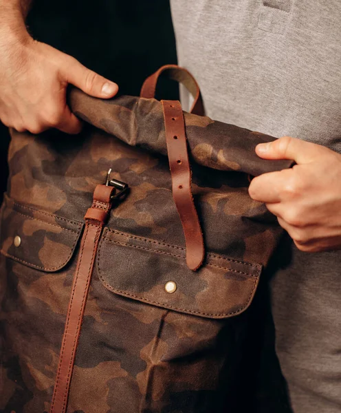man\'s hand holding a canvas backpack. Model wears a brown belt bag, Medium Leather Backpack Man Rolltop Leather Rucksack Bag