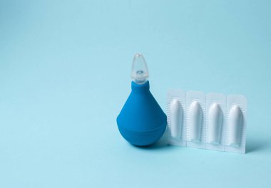 Mavi arka planda anal ya da vajinal kullanım için lavman ve fitil. Hemoroit, sıcaklık, ardıç, iltihap tedavisi için mumlar