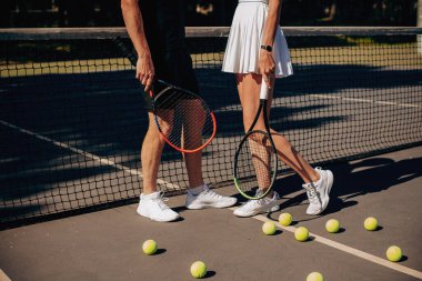 Tenisçi bir çiftin ince bacakları. Tenis kortunda spor ayakkabılı ince bacaklar.