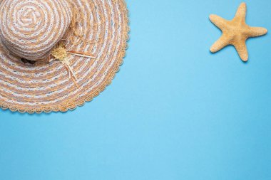 Yaz ve tatil dairesi, hasır şapka ve mavi arka planda yıldız balığıyla yatıyordu..