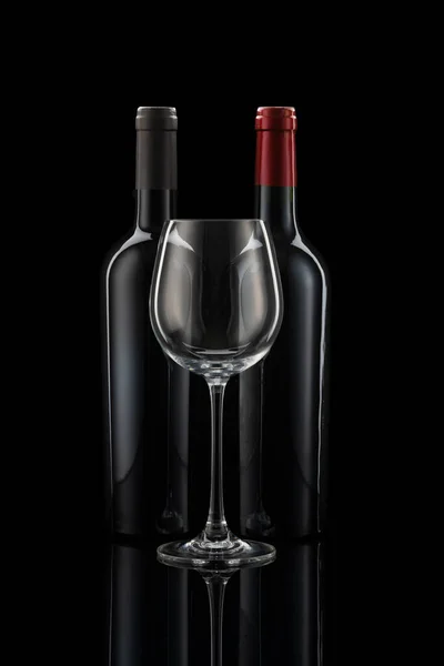 Twee Wijnflessen Naast Elkaar Een Wijnglas Voor Een Zwarte Achtergrond — Stockfoto