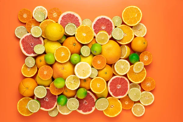果香和多汁水果的概念 顶部视图 鲜切片 半熟和整个柑橘类水果几乎完全覆盖橙色背景 — 图库照片