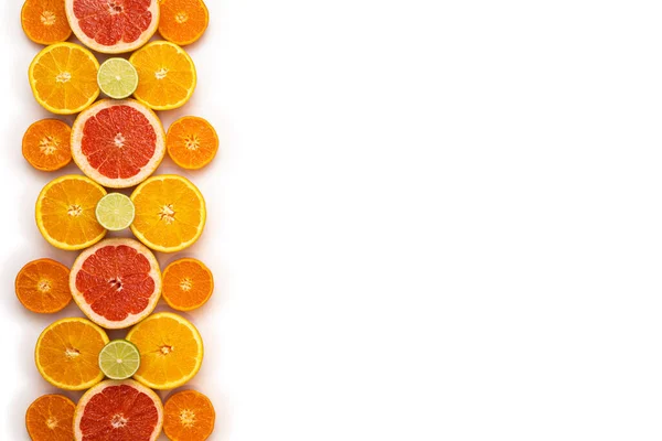 新鮮でフルーティーでジューシーなフルーツのコンセプト 最上階だ 白を基調としたイメージの左3分の1のパターンとして 生のスライスと半分の柑橘系の果物 — ストック写真